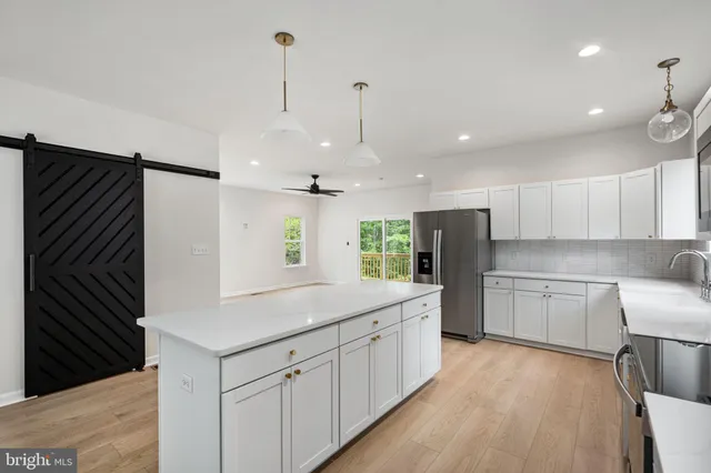 a large kitchen with stainless steel appliances granite countertop a sink a stove and a refrigerator