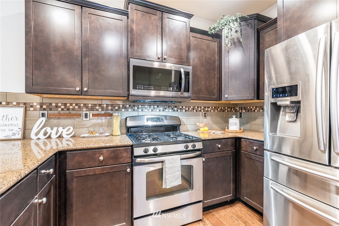 17809 46th Drive Southeast Bothell, WA 98012 - Photo 13 of 35 a kitchen with stainless steel appliances granite countertop a refrigerator stove and sink