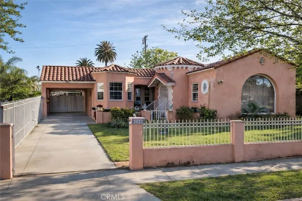 a front view of a house with a garden and plants