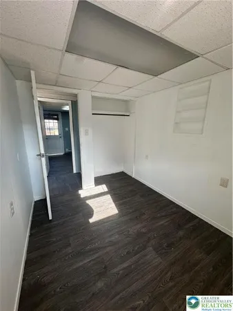 an empty room with wooden floor and cabinet