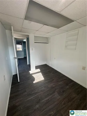 an empty room with wooden floor and cabinet