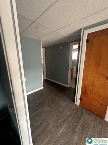 an empty room with wooden floor and entrance