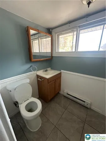 a bathroom with a sink toilet and window