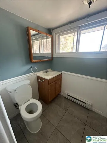 a bathroom with a sink toilet and window