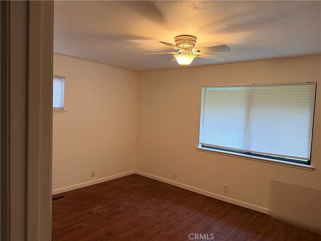 6402 Corning Court Magalia, CA 95954 - Photo 9 of 15 an empty room with wooden floor chandelier fan and windows