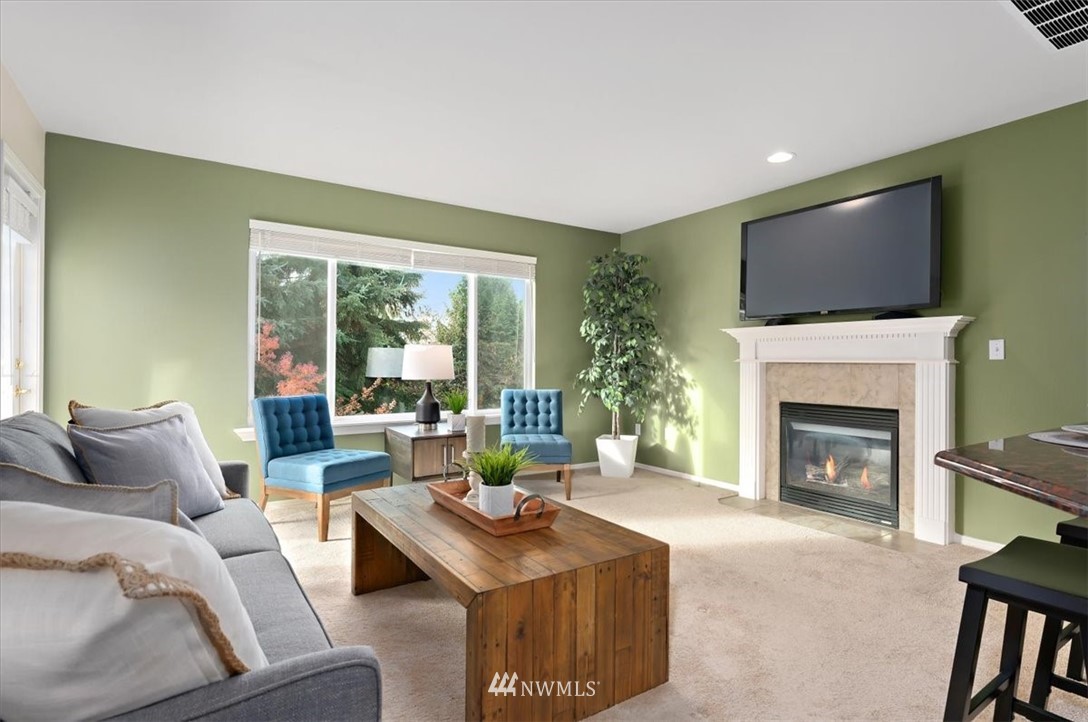 18346 Rainier View Road Southeast Monroe, WA 98272 - Photo 13 of 40 a living room with furniture a fireplace and a flat screen tv