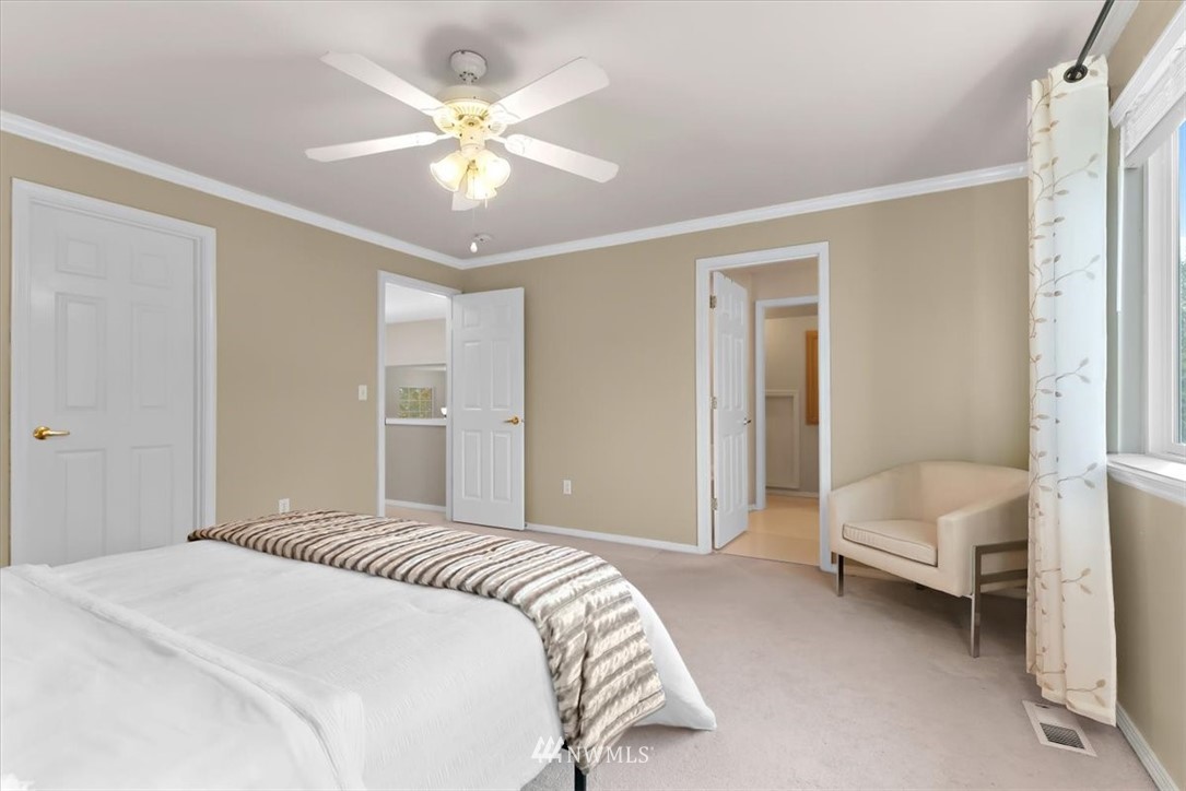 18346 Rainier View Road Southeast Monroe, WA 98272 - Photo 20 of 40 a bedroom with a white bed and a chandelier