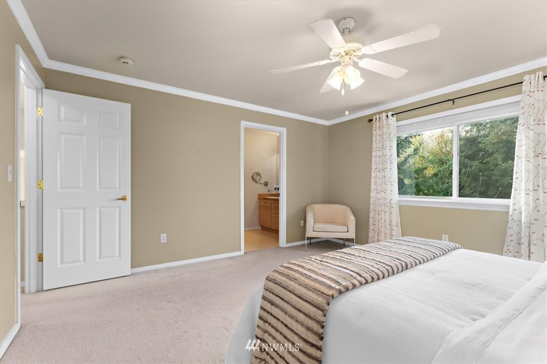 18346 Rainier View Road Southeast Monroe, WA 98272 - Photo 25 of 40 a bedroom with a large bed and a chandelier