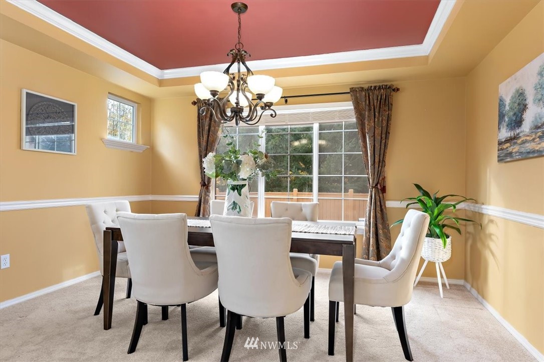 18346 Rainier View Road Southeast Monroe, WA 98272 - Photo 6 of 40 a view of a dining room with furniture a chandelier and wooden floor