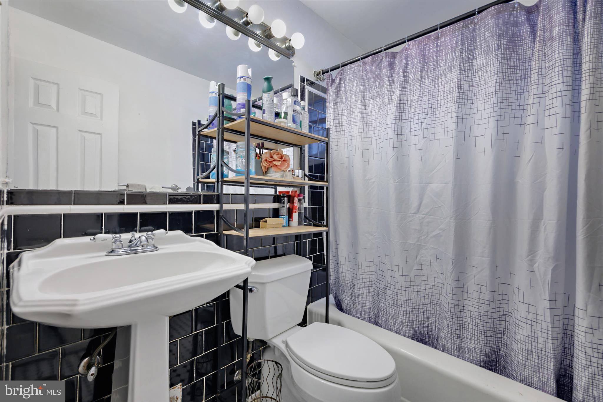 5401 Kenmont Road Oxon Hill, MD 20745 - Photo 20 of 39 a bathroom with a sink a toilet and shower curtain