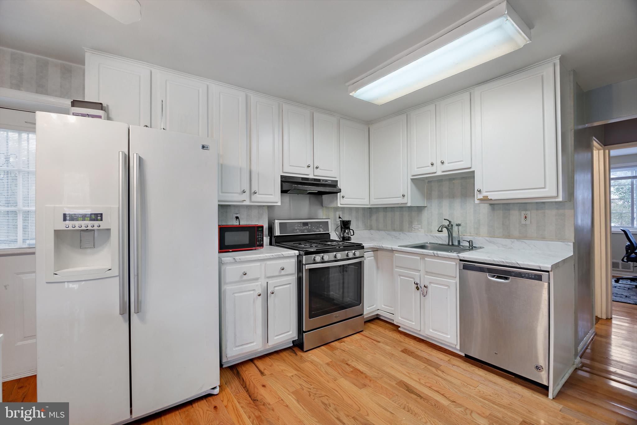 5401 Kenmont Road Oxon Hill, MD 20745 - Photo 8 of 39 a kitchen with stainless steel appliances granite countertop a refrigerator stove a sink and white cabinets