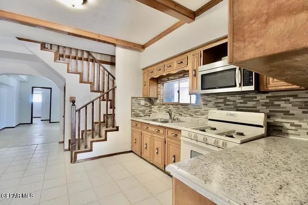 a kitchen with stainless steel appliances kitchen island granite countertop a stove a sink and a microwave