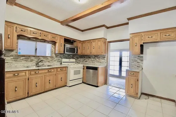 a kitchen with stainless steel appliances granite countertop a refrigerator and wooden cabinets