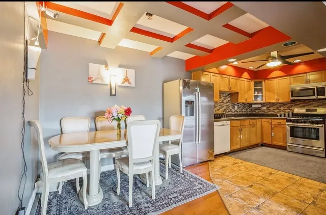 a kitchen with a dining table chairs and white appliances