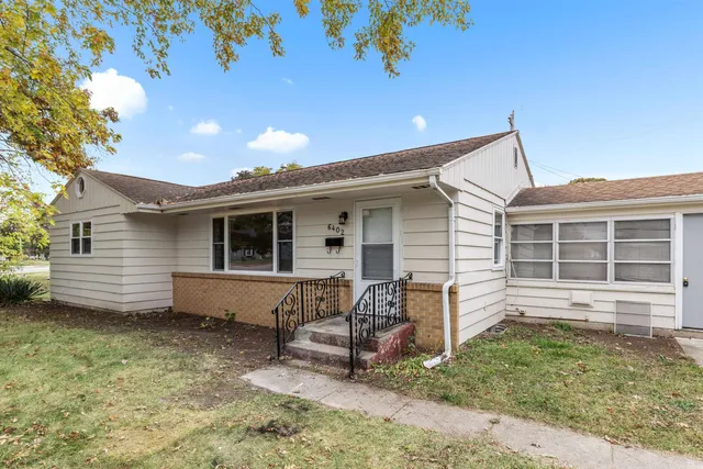 a view of a house with a backyard and chairs