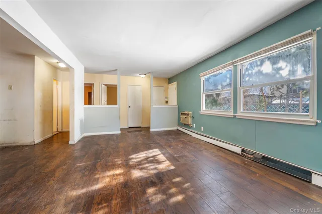a view of a big room with wooden floor and windows