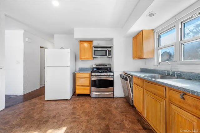 a kitchen with a refrigerator a stove a sink cabinets and a dining table