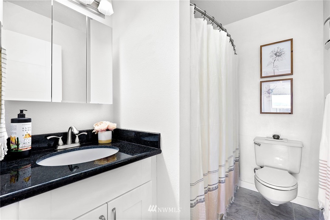 507 West Mercer Street, Unit 603 Seattle, WA 98119 - Photo 13 of 21 a bathroom with a granite countertop sink and a toilet