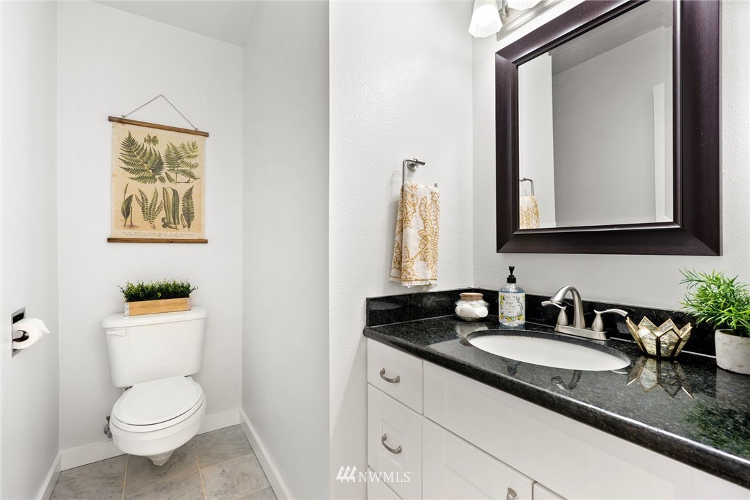 507 West Mercer Street, Unit 603 Seattle, WA 98119 - Photo 15 of 21 a bathroom with a granite countertop toilet sink and mirror
