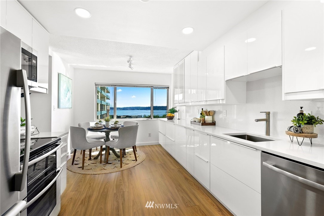 507 West Mercer Street, Unit 603 Seattle, WA 98119 - Photo 6 of 21 a kitchen with a sink appliances dining table and chairs