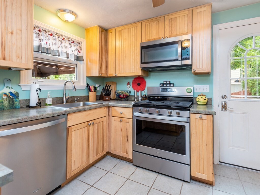 97 Sandy Beach Road Holland, MA 01521 - Photo 15 of 41 a kitchen with stainless steel appliances granite countertop a stove a sink and a microwave