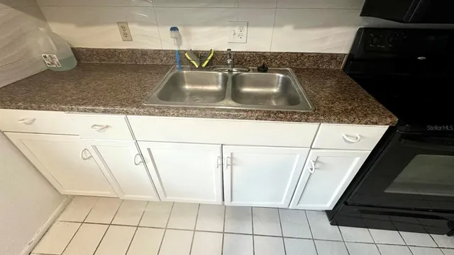 a kitchen with granite countertop a sink and a stove