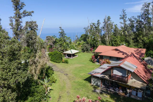 an aerial view of a house with swimming pool and garden