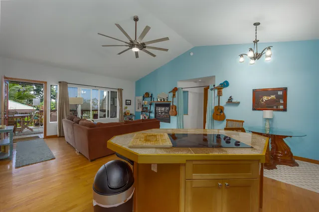 a dining hall with a dining table chairs with wooden floor and chandelier