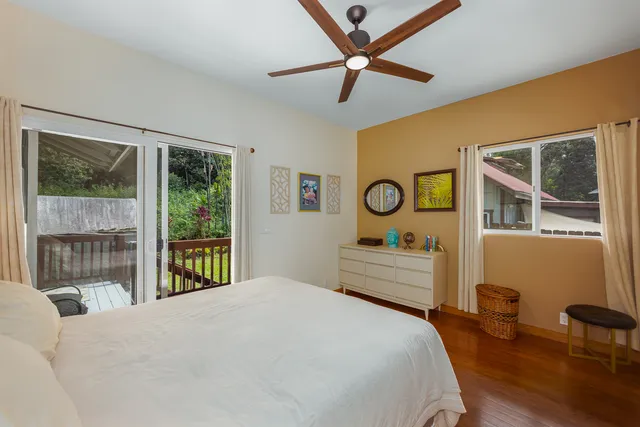 a bedroom with a bed and a large window with the outer view