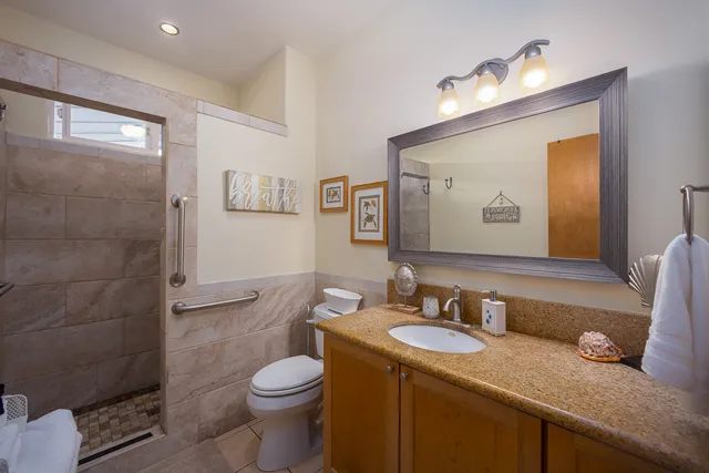 a bathroom with a granite countertop toilet sink and mirror