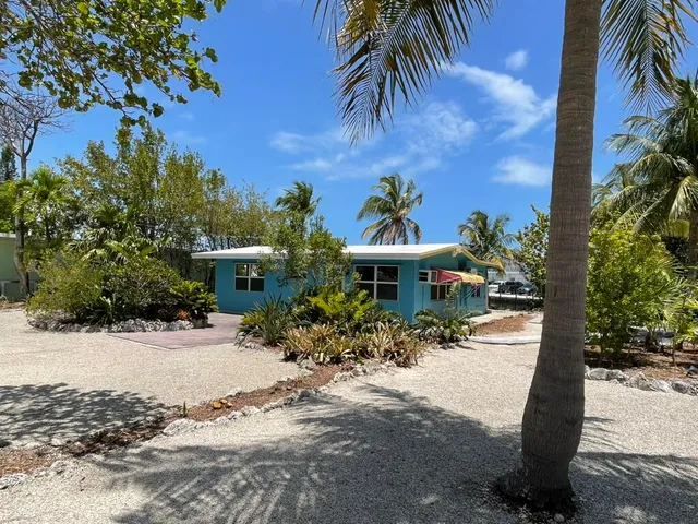 a front view of a house with a yard and potted plants