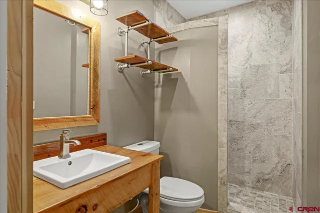 a bathroom with a sink a toilet and shower