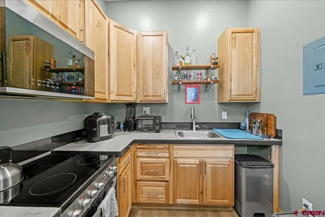 a kitchen with kitchen island granite countertop a sink stove and cabinets