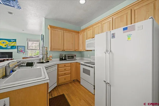 a kitchen with a refrigerator a stove top oven a sink and cabinets