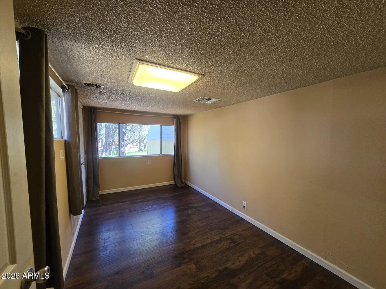 118 East Frontier Street Payson, AZ 85541 - Photo 7 of 22 an empty room with wooden floor and windows