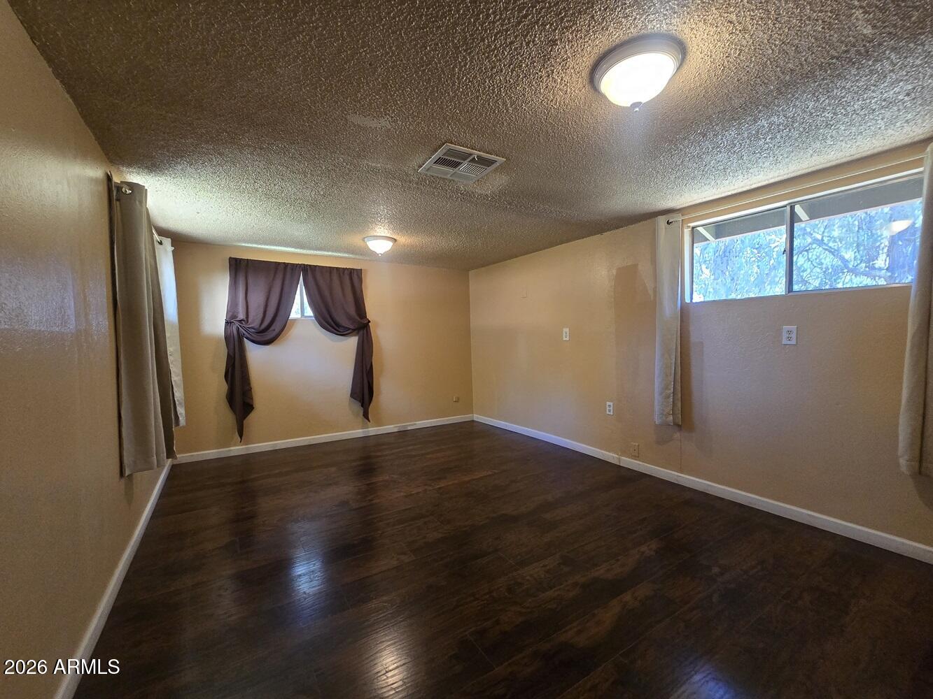 118 East Frontier Street Payson, AZ 85541 - Photo 8 of 22 an empty room with wooden floor and windows