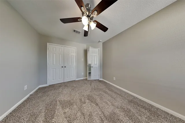 en empty room with ceiling fan and window