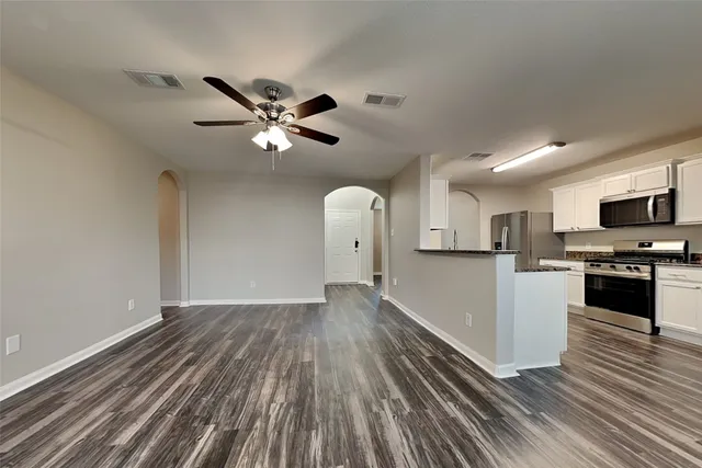 a view of a kitchen with wooden floor and stainless steel appliances