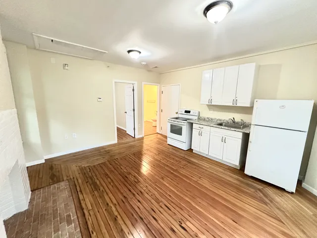 a kitchen with granite countertop white cabinets and white appliances