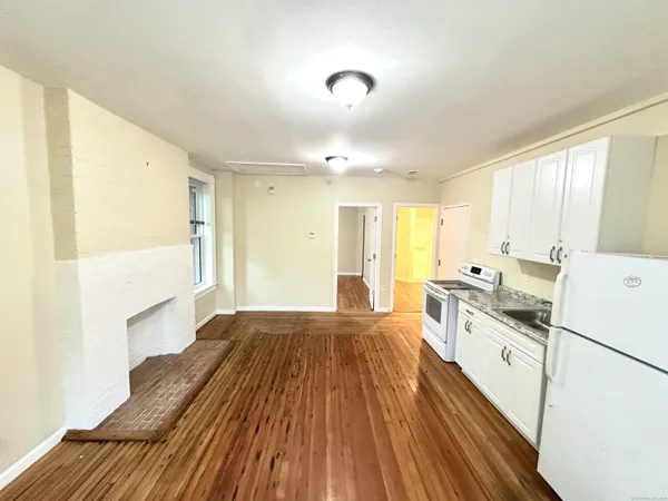 a kitchen with a sink and wooden floor
