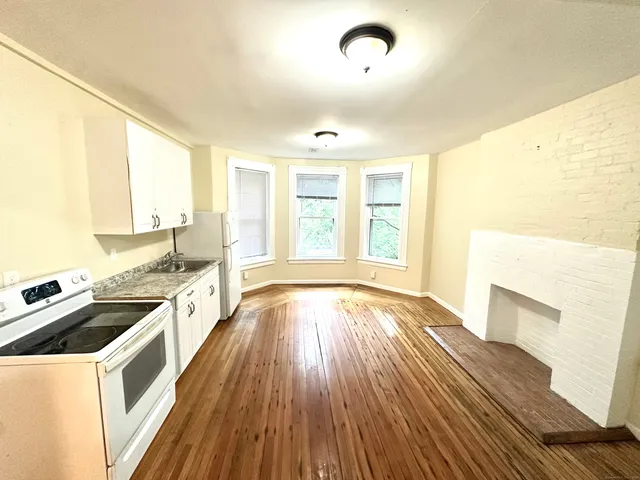 a open kitchen with a sink and wooden floor