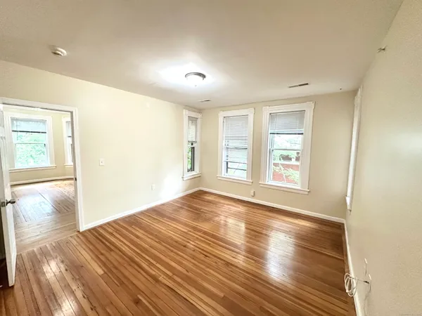 wooden floor in an empty room with a window