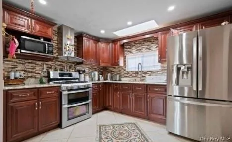 a kitchen with stainless steel appliances granite countertop a refrigerator stove and sink