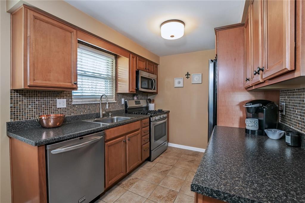 171 Mary Reed Road Baden, PA 15005 - Photo 6 of 25 a kitchen with stainless steel appliances granite countertop a sink stove and cabinets