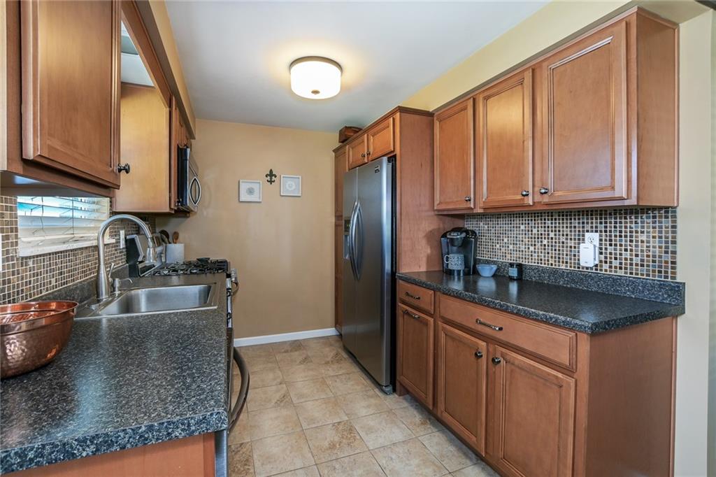 171 Mary Reed Road Baden, PA 15005 - Photo 7 of 25 a kitchen with stainless steel appliances granite countertop a sink stove and refrigerator