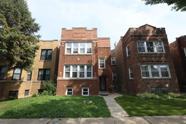 a front view of a residential apartment building with a yard