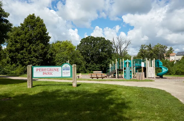 a sign board with a play ground in the back