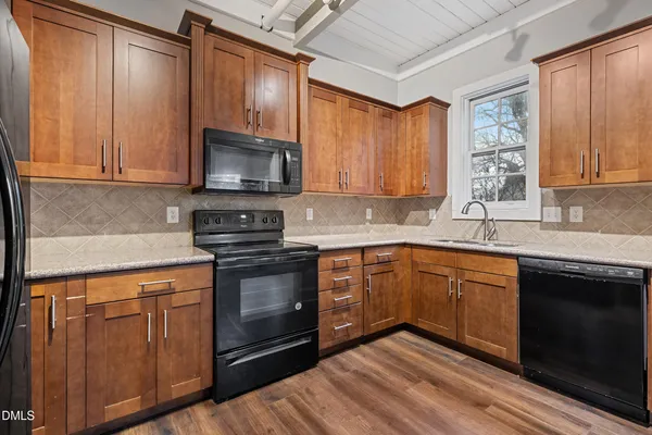 a kitchen with stainless steel appliances granite countertop wooden cabinets stove top oven and sink