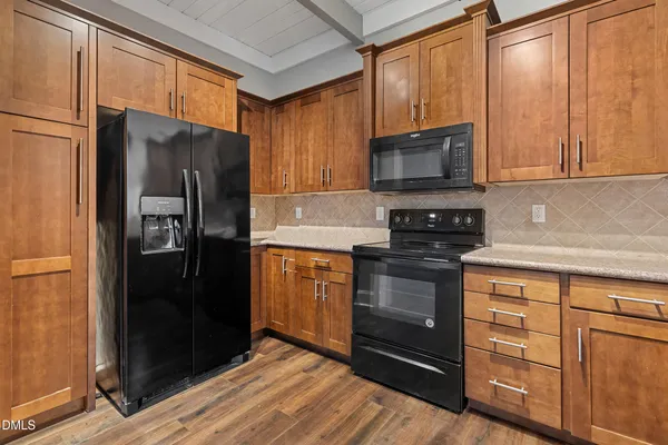 a kitchen with stainless steel appliances granite countertop a refrigerator stove and microwave