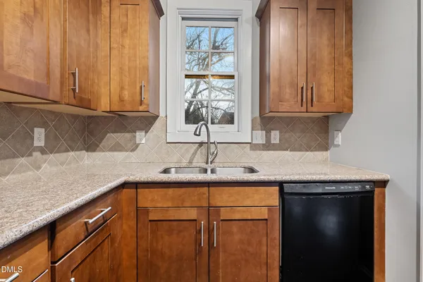 a kitchen with granite countertop cabinets stainless steel appliances and a sink